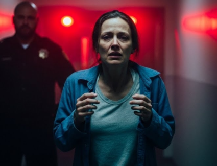 A distressed woman walks down a dim institutional hallway as an authority figure follows, symbolizing fear, trauma, and the failure of institutions to protect survivors in Illinois.