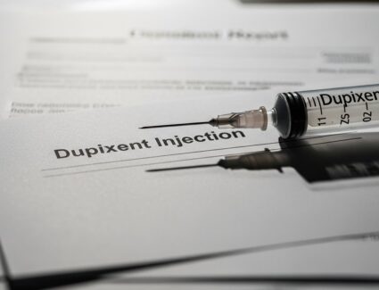 Syringe labeled Dupixent placed on medical documents, symbolizing emerging legal claims and safety concerns related to long-term Dupixent use.