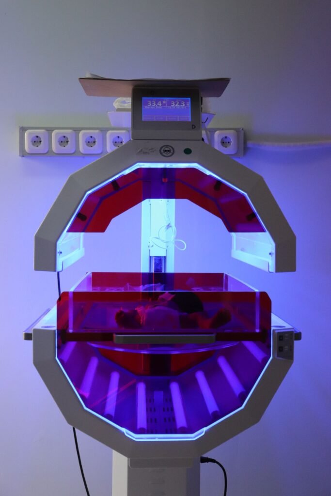 NEC baby formula lawsuit: neonatal incubator unit lit with purple light in a hospital room