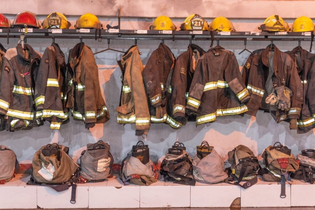 AFFF MDL: rows of firefighter turnout coats and helmets hanging in a fire station