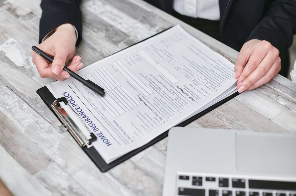 Edison Eaton Fire offer: hands holding a pen while reviewing a home insurance policy document