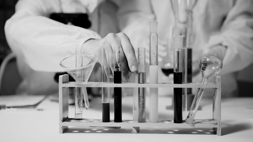 Biologic drug lymphoma risk: gloved hand handling test tubes in a research laboratory