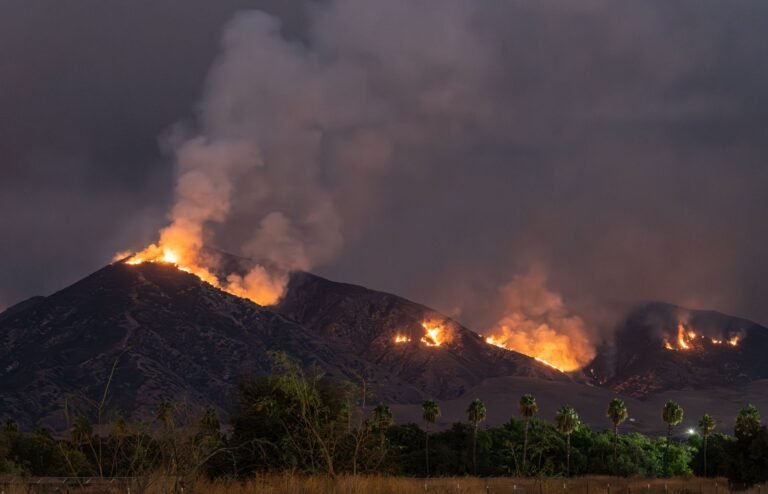 California wildfire lawsuit: wildfire burning across dark hills at night in Southern California