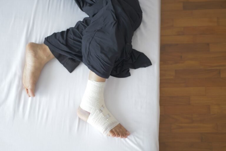 Cartiva revision surgery: bandaged foot resting on a bed during recovery from surgery