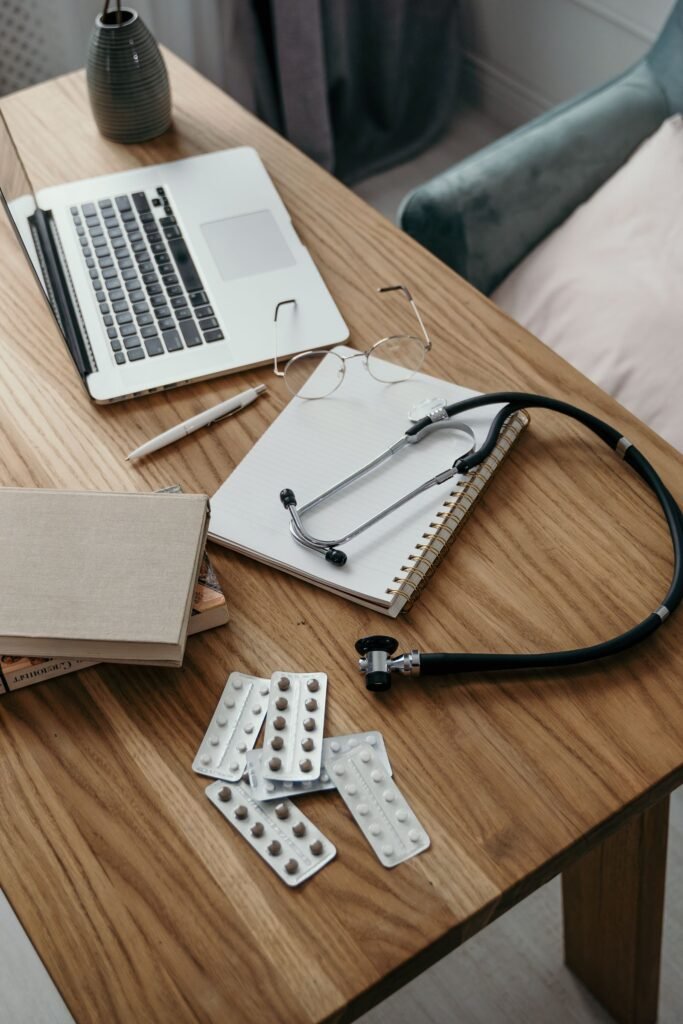 Depo-Provera lawsuit: stethoscope, pills and notepad on a wooden desk beside a laptop