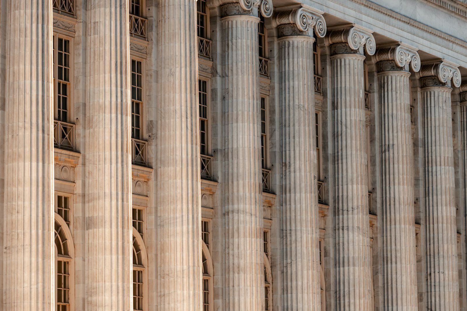 Stone courthouse facade with tall columns and a clock