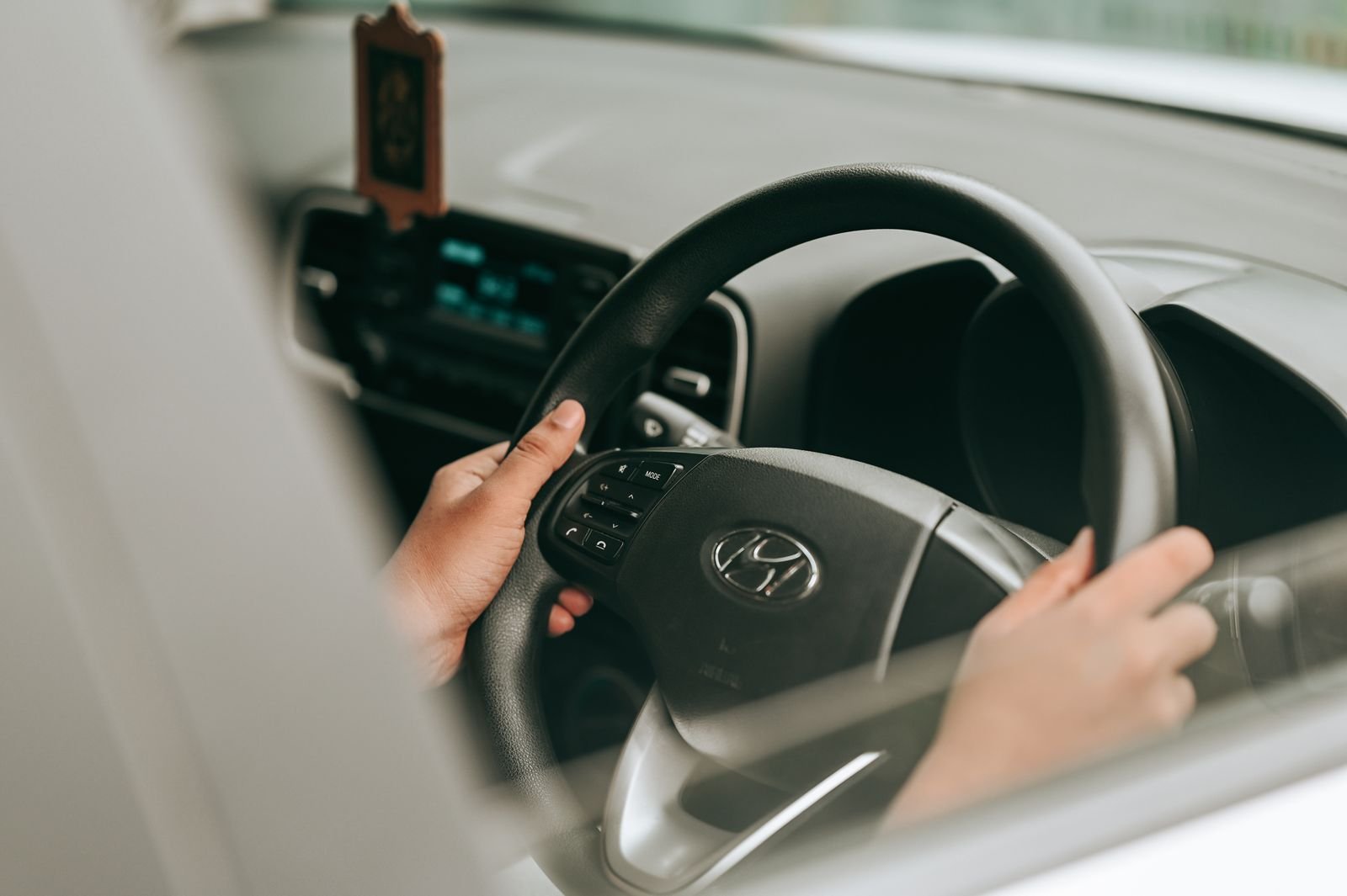 Rideshare driver injury claims: close-up of a driver's hands on a car steering wheel