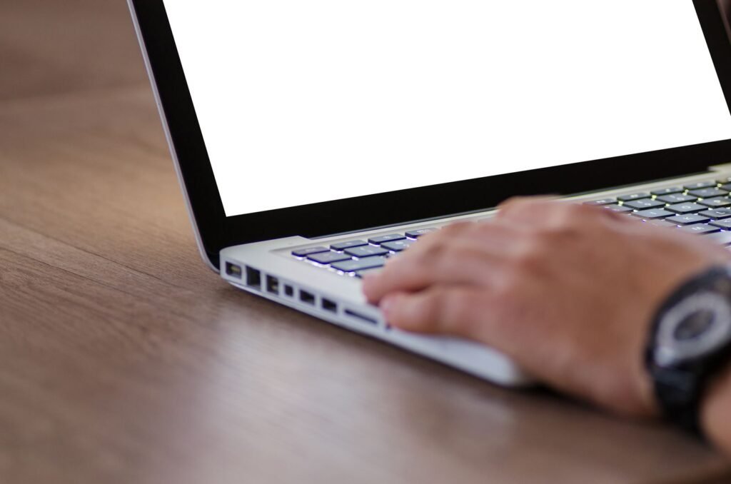 Dupixent lymphoma: hand resting on a laptop keyboard with a blank screen, ready to fill out an online form