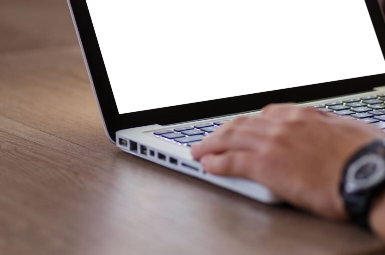 Dupixent lymphoma: hand resting on a laptop keyboard with a blank screen, ready to fill out an online form