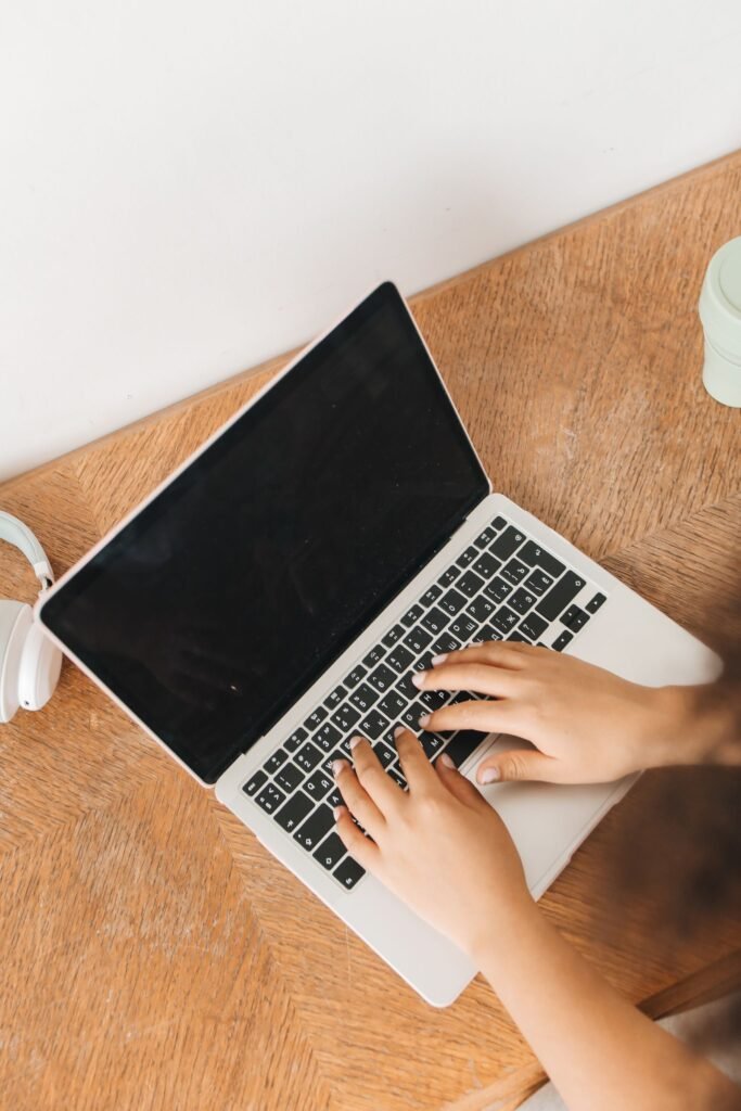 Dupixent lymphoma: top-down view of hands typing on a laptop on a wooden table