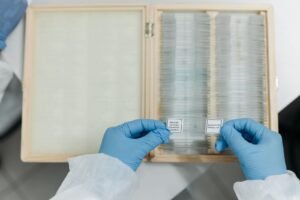 Dupixent FDA safety review: gloved hands holding a microscope slide in a lab, representing drug safety research