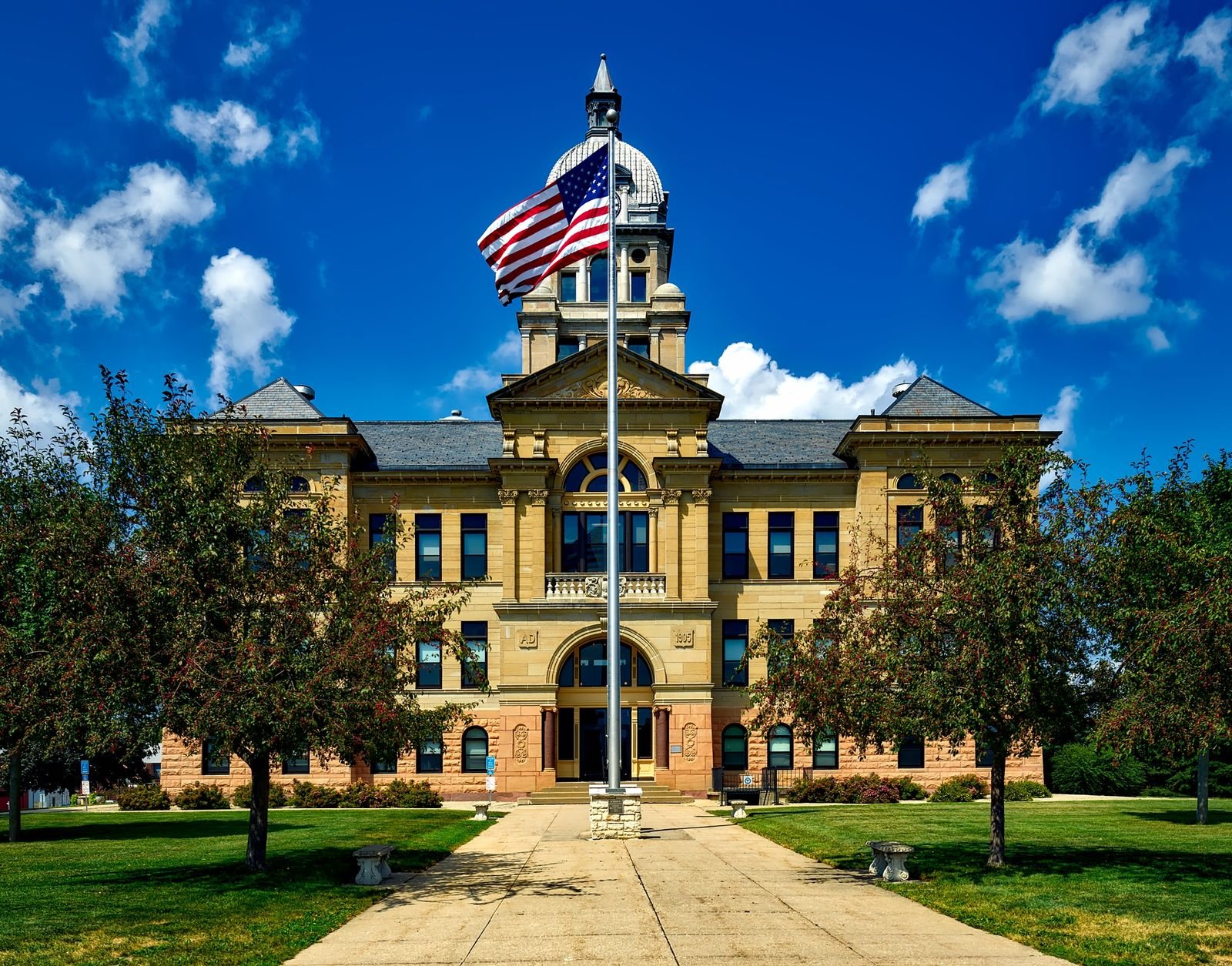 Dupixent lawsuit update: courthouse exterior with an American flag against a bright blue sky