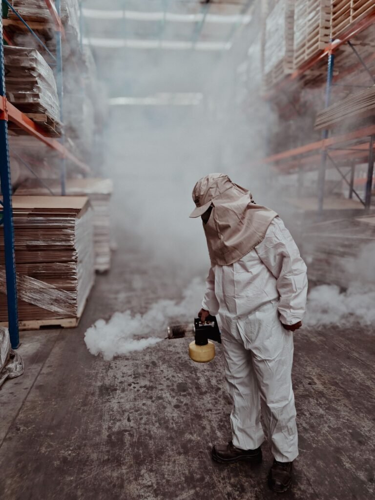 Chlorpyrifos Parkinson's lawsuit: pest control worker in protective gear fumigating a warehouse, face not visible