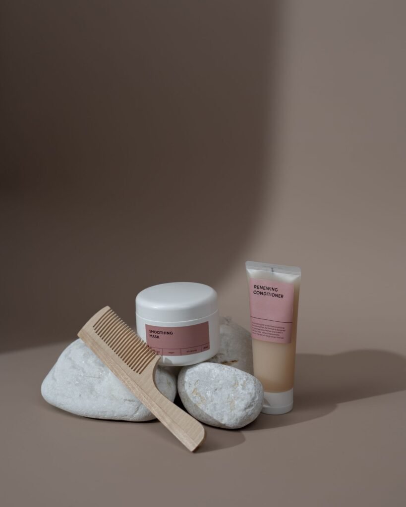 Hair relaxer uterine cancer: a comb next to plain beauty product containers on a neutral background
