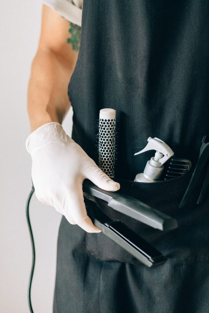 Hair relaxer lawsuit for salon workers: stylist apron holding a brush and flat iron, no face shown