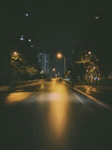Rideshare assault survivors: quiet city street at night lit by warm streetlamps