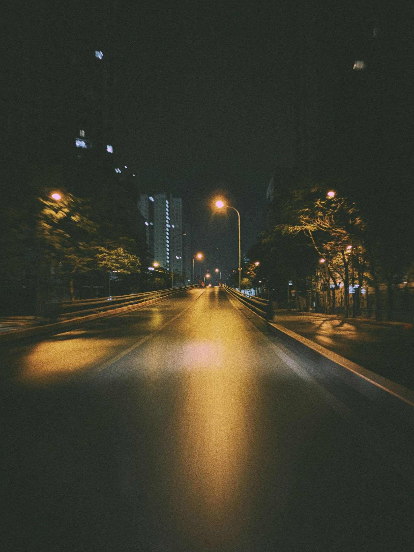 Rideshare assault survivors: quiet city street at night lit by warm streetlamps
