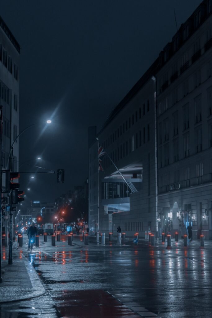 Rideshare assault survivors: wet city street at night reflecting lights after rain