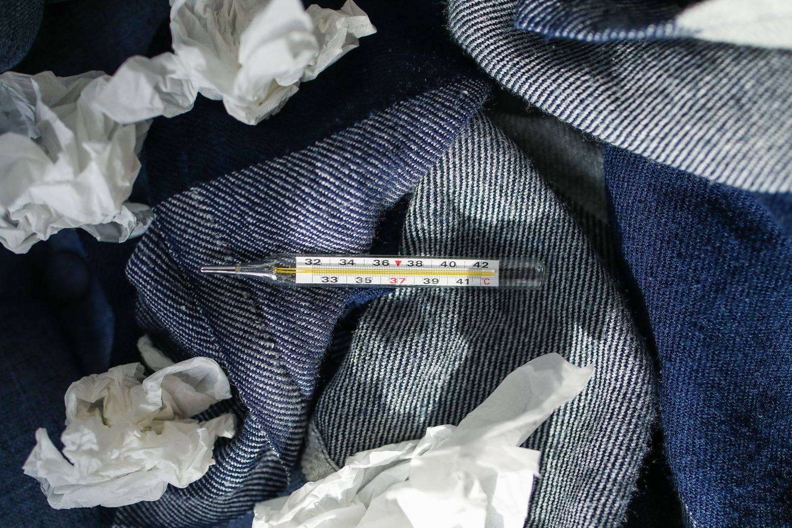 Implanted port warning signs: digital thermometer and tissues resting on a blanket