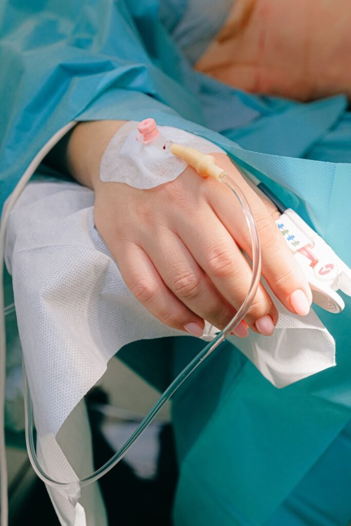 Implanted port warning signs: close-up of a patient's hand with an IV line in a hospital