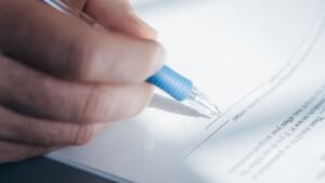 Car accident free case review: close-up of a hand holding a pen and filling out a paper form