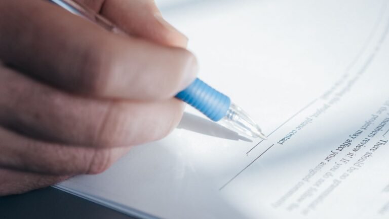 Car accident free case review: close-up of a hand holding a pen and filling out a paper form