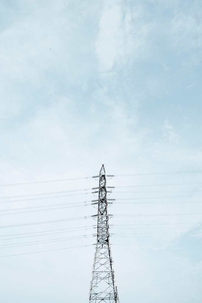 Inverse condemnation: high-voltage transmission tower and power lines against a cloudy sky