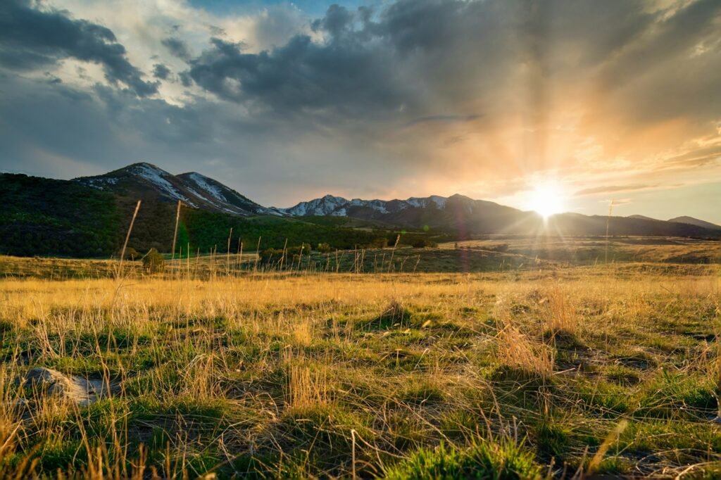 LDS Church abuse lawsuit: sunset over the Wasatch mountains in Utah with green fields
