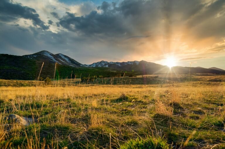 LDS Church abuse lawsuit: sunset over the Wasatch mountains in Utah with green fields