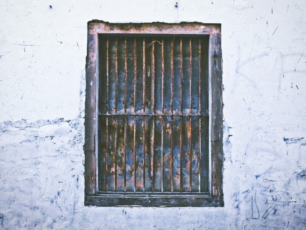 Maryland juvenile facility abuse: barred window on a weathered building wall