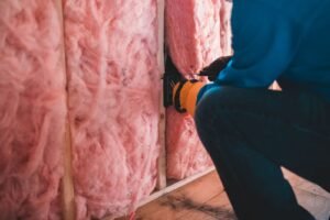 Mesothelioma compensation: gloved worker installing insulation inside a building, face not shown