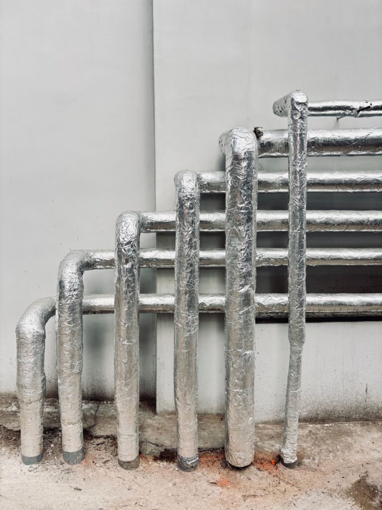 Mesothelioma compensation: silver insulated pipes running up the outside of an industrial building