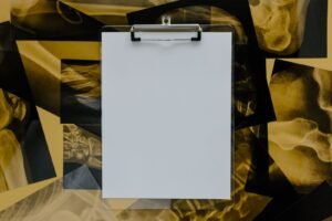 Mesothelioma evidence standards: blank clipboard lying on top of several x-ray films