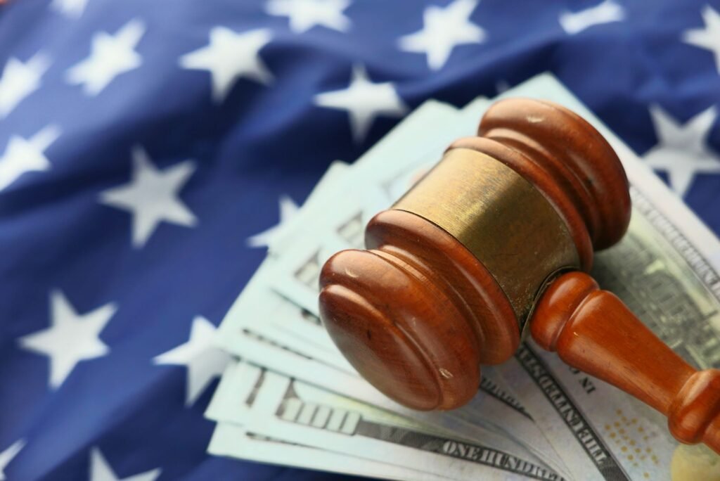 Mesothelioma lawsuit settlements: wooden gavel resting on U.S. dollar bills, representing settlements