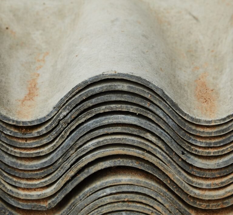 Mesothelioma lawsuits: stack of weathered corrugated roofing sheets showing age and wear