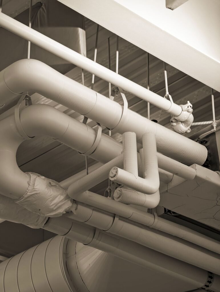 Mesothelioma lawsuits: network of old industrial pipes and ducts in sepia tone
