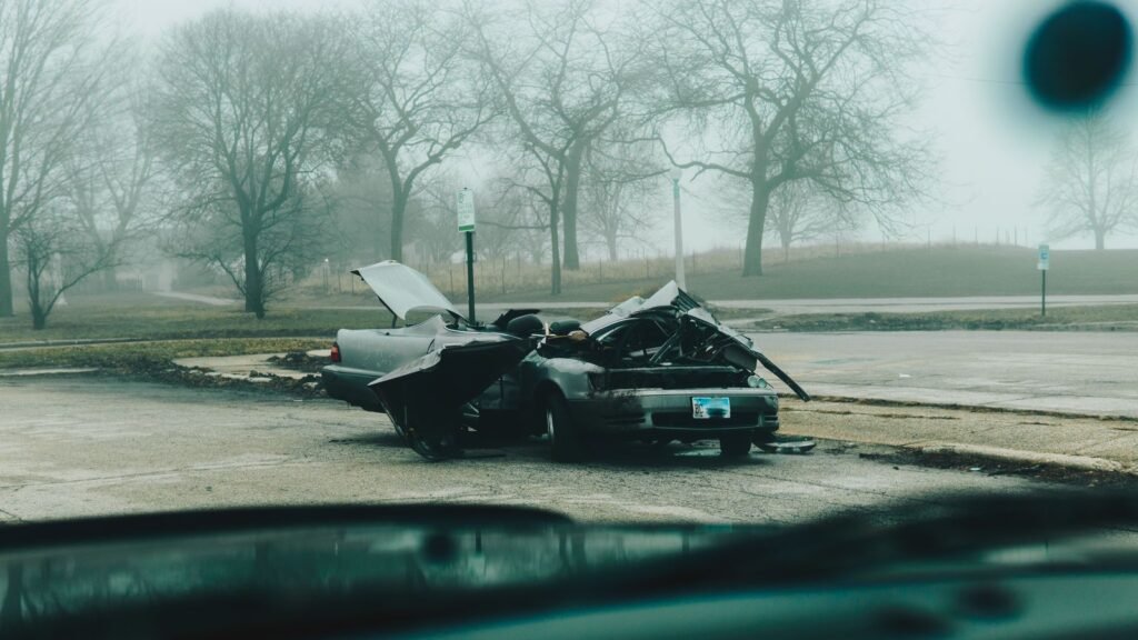 Motor vehicle accident lawsuit steps: badly damaged car on a quiet, foggy city street after a crash