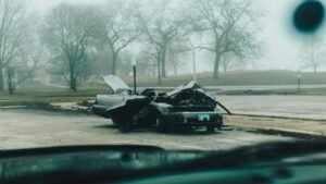 Motor vehicle accident lawsuit steps: badly damaged car on a quiet, foggy city street after a crash