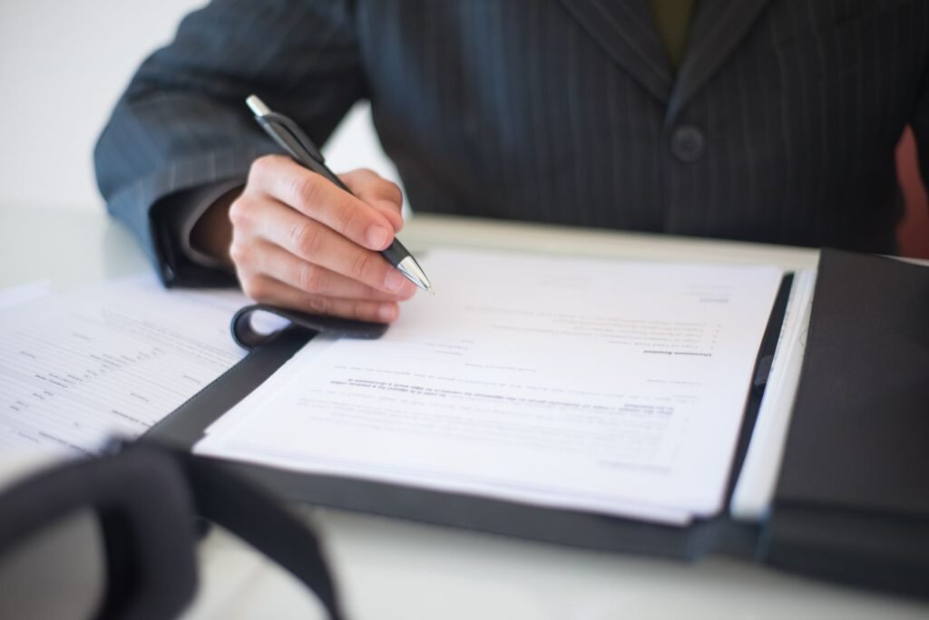 Motor vehicle accident lawsuit steps: close-up of a hand signing documents with a pen