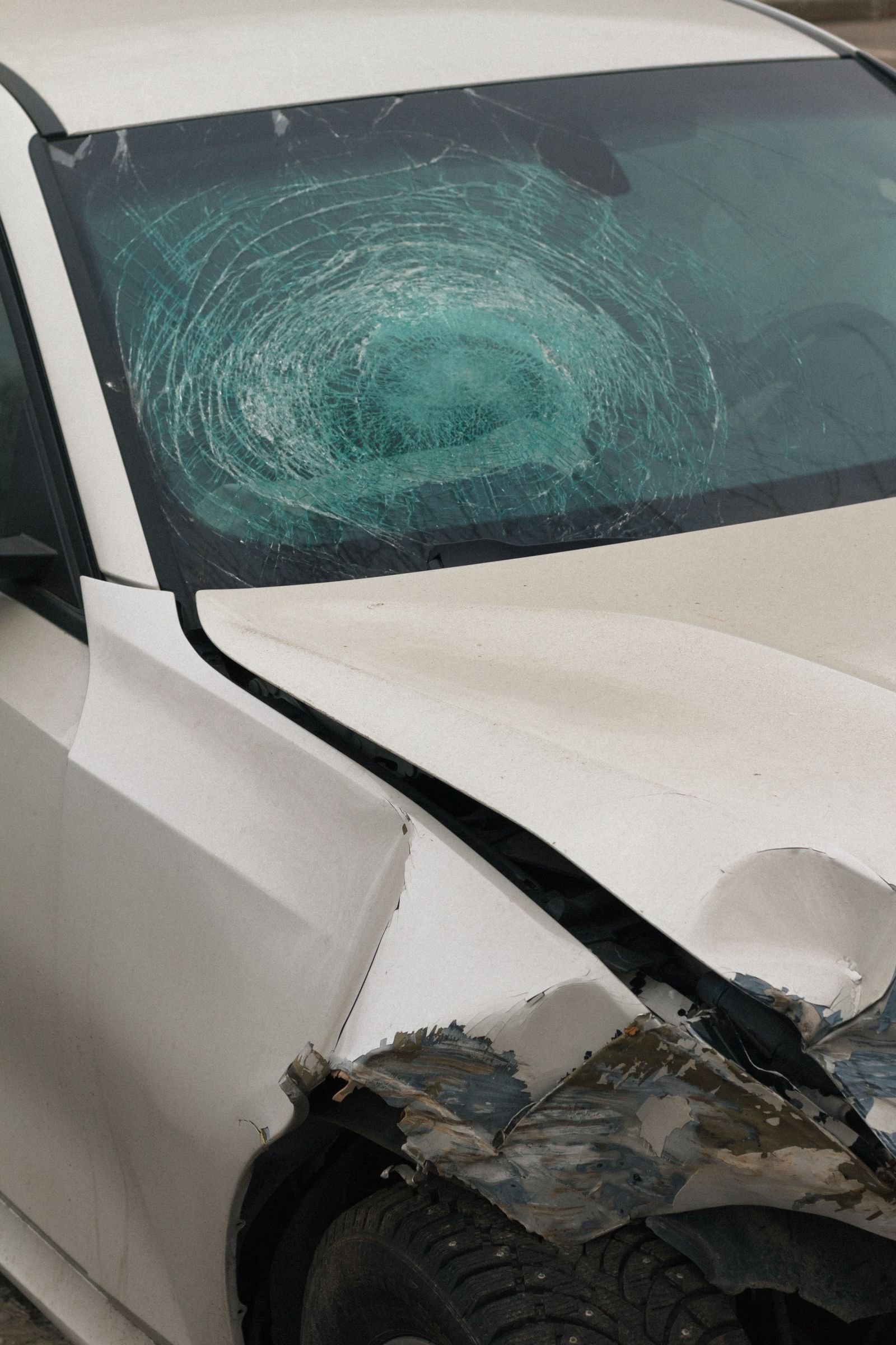Car crash lawsuits: damaged car with a shattered windshield and crumpled front end after a crash