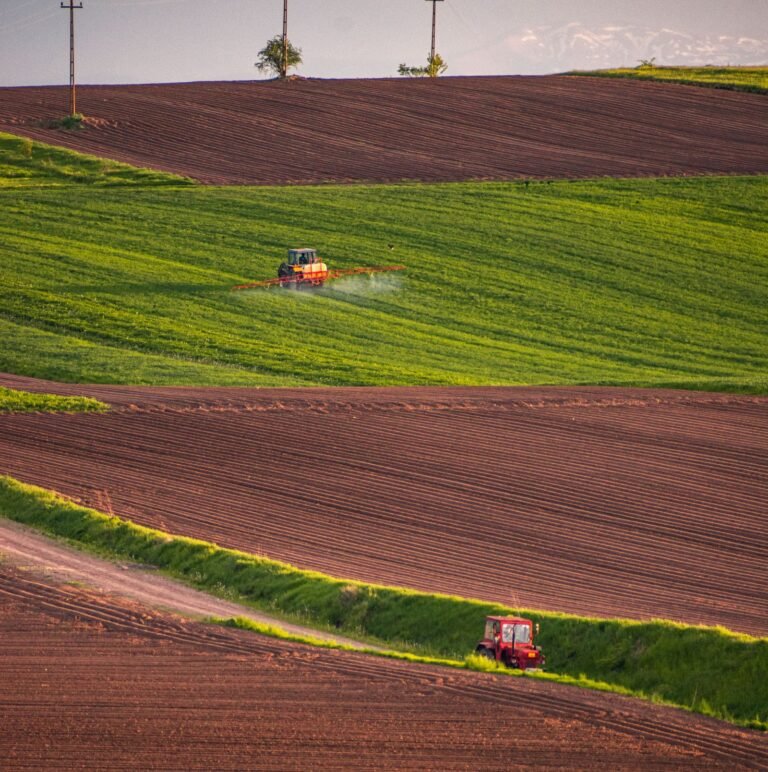 Paraquat lawsuits: tractors spraying crop fields at sunset across green and plowed farmland