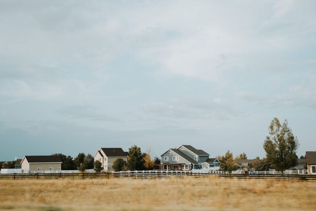 Paraquat lawsuits: rural homes beside an open field and wooden fence under a wide sky