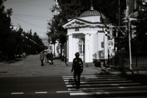 Pedestrian or cyclist injury: pedestrian crossing a city street at a zebra crosswalk, seen from a distance