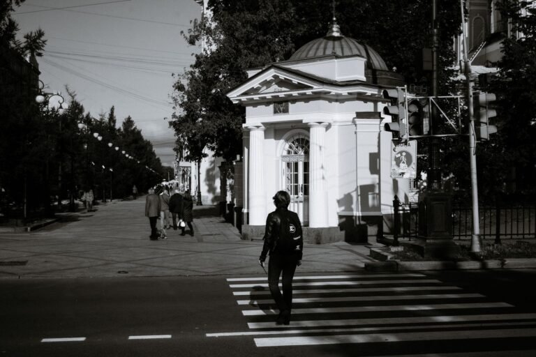 Pedestrian or cyclist injury: pedestrian crossing a city street at a zebra crosswalk, seen from a distance