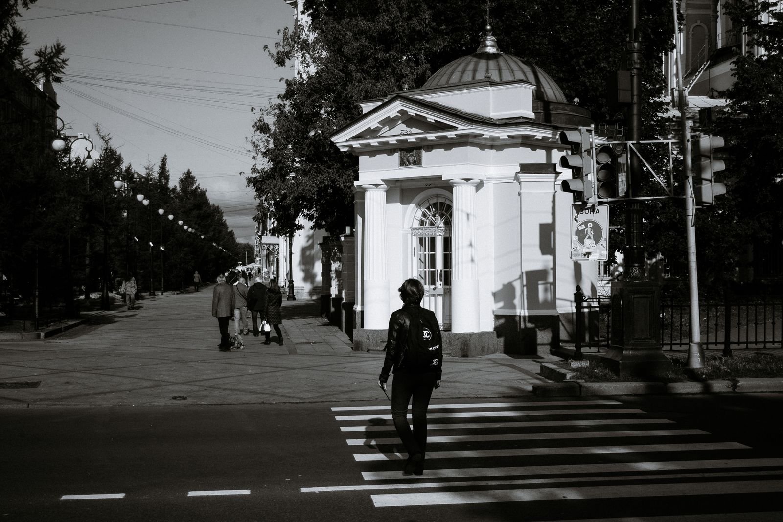 Pedestrian or cyclist injury: pedestrian crossing a city street at a zebra crosswalk, seen from a distance