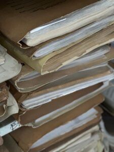 Chlorpyrifos exposure evidence: stack of old paper files in brown folders, like work and medical records gathered for a claim