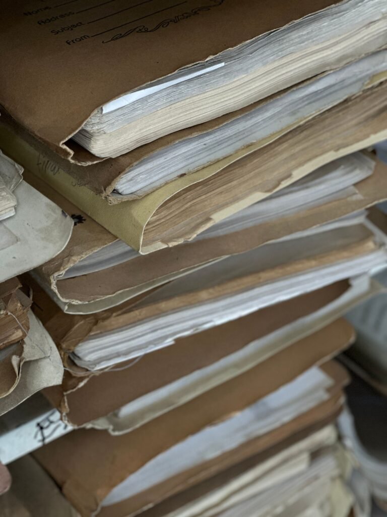Chlorpyrifos exposure evidence: stack of old paper files in brown folders, like work and medical records gathered for a claim