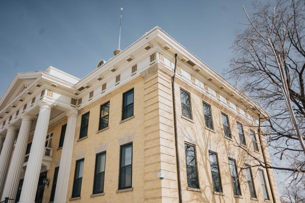 Rideshare assault lawsuit: low-angle view of a historic courthouse with columns against a blue sky
