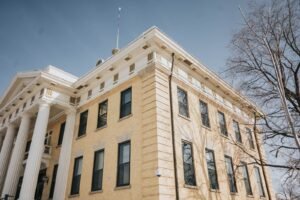 Rideshare assault lawsuit: low-angle view of a historic courthouse with columns against a blue sky