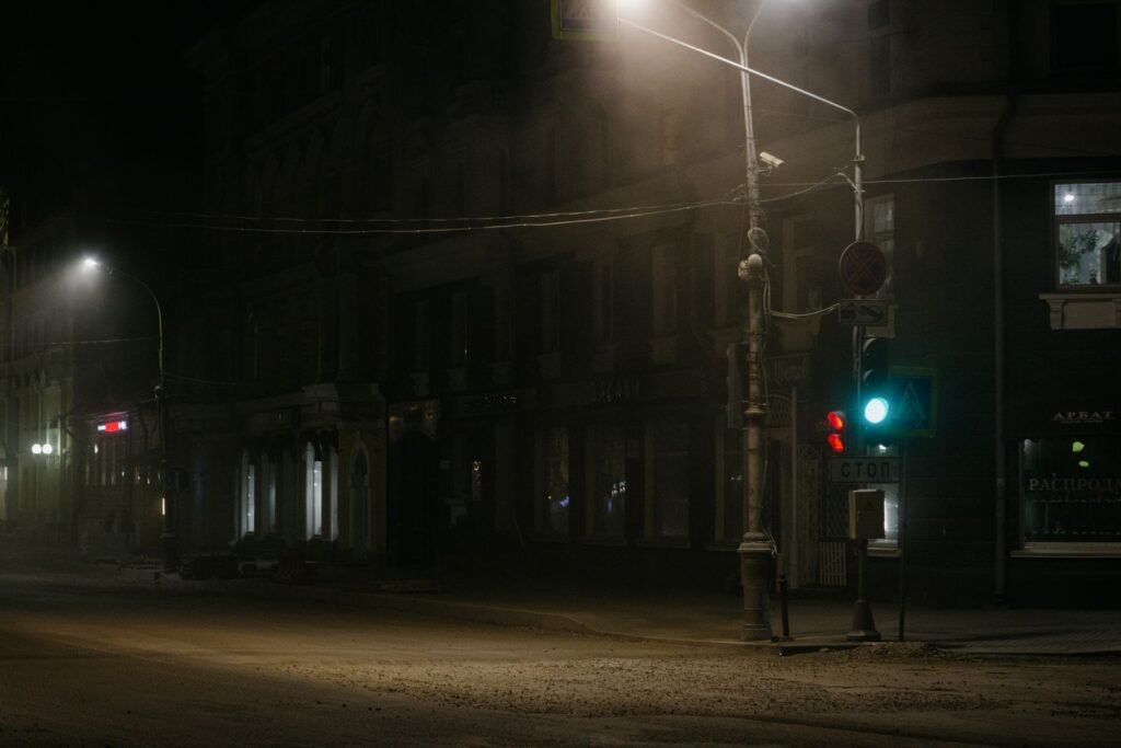 Rideshare assault lawsuit: empty city street at night with traffic lights in the mist